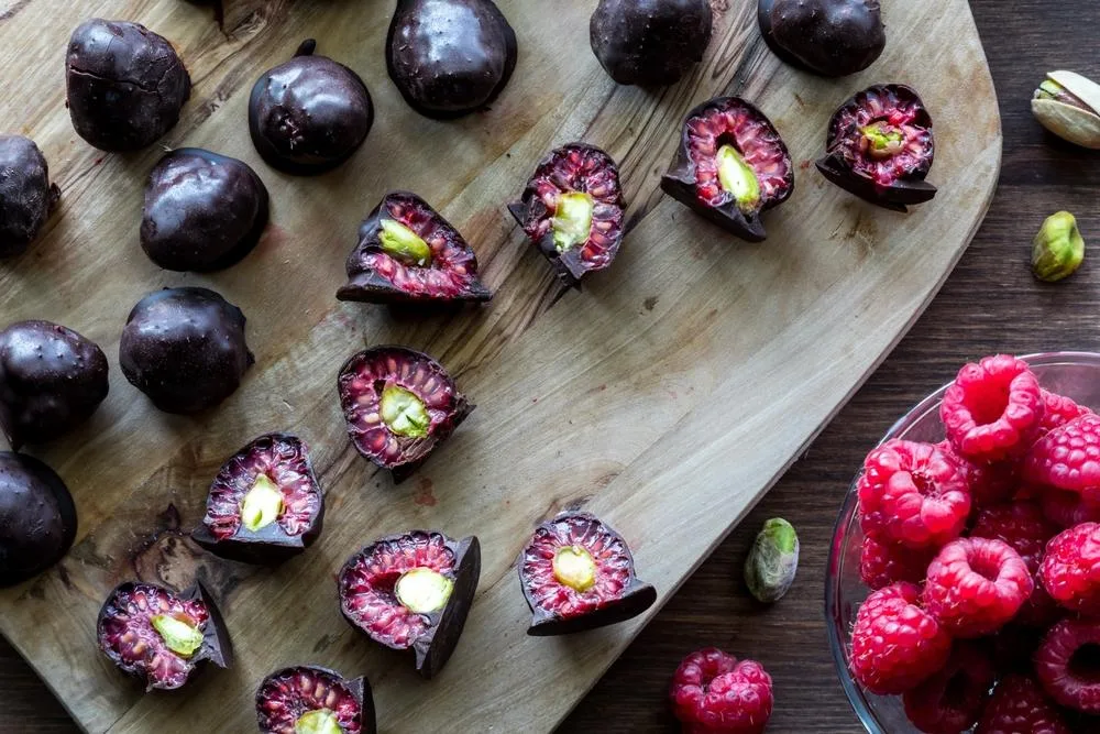 Berries have antioxidants and fiber while dark chocolate is noted for its polyphenolic compounds.