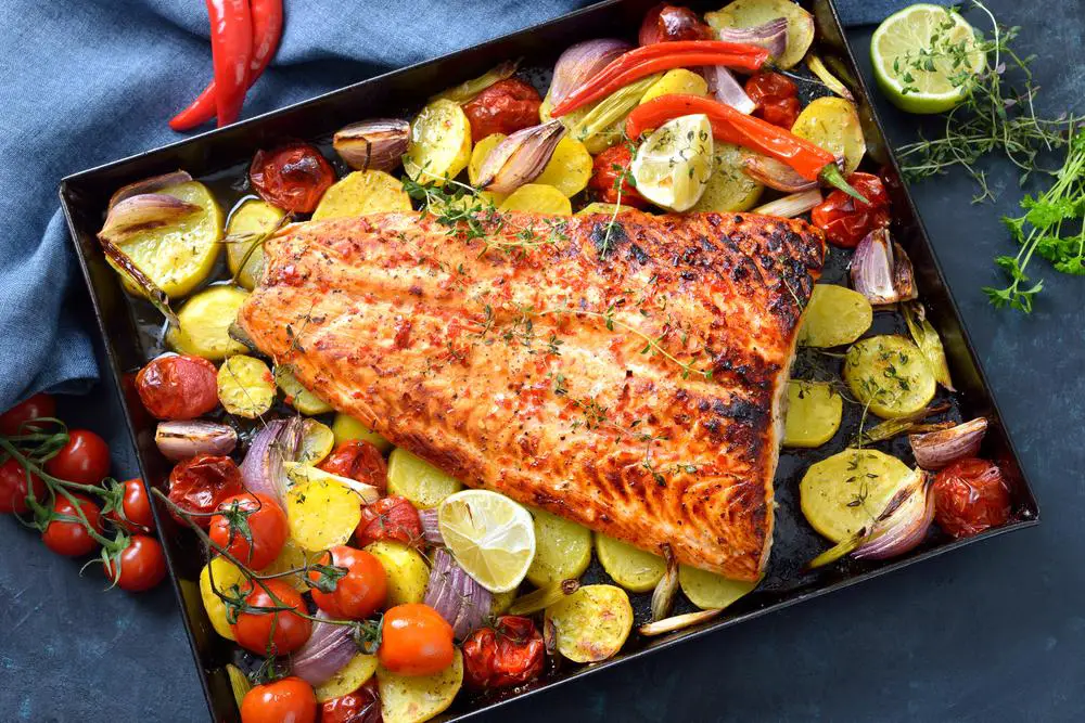 Spicy baked salmon with citruses, potatoes, tomatoes, chili, and red onions.