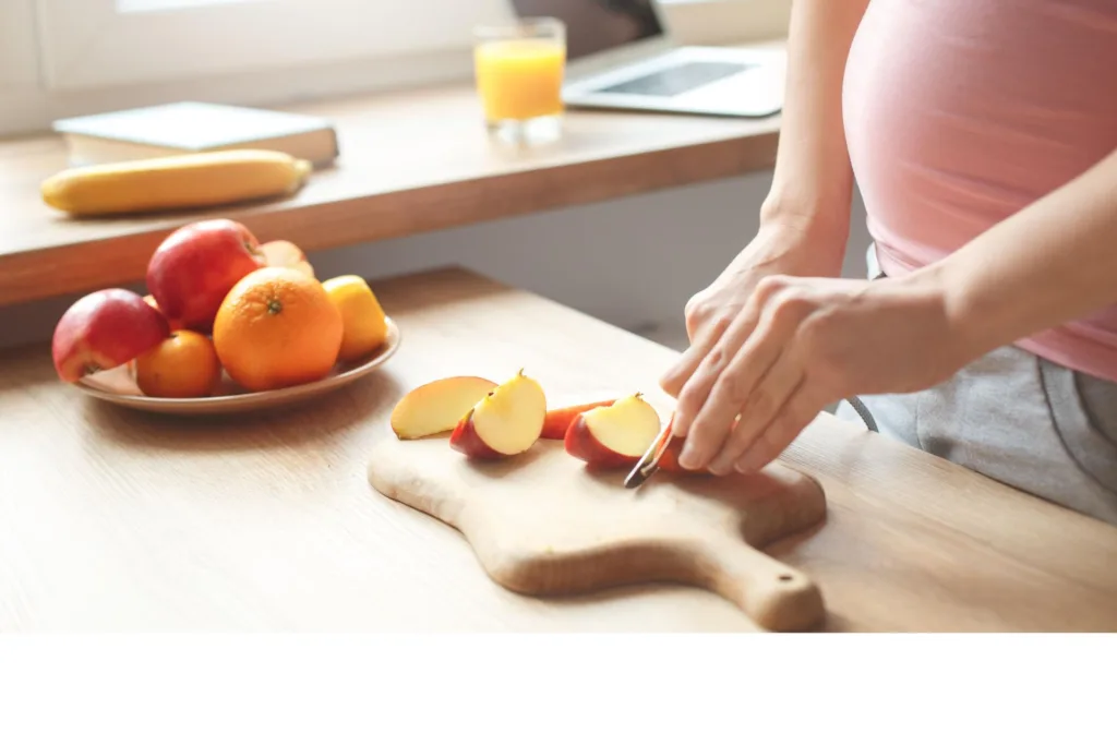 Young pregnant woman in the kitchen at home healthy snack